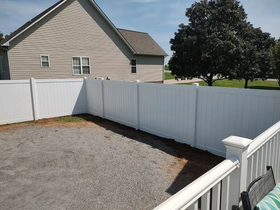 White vinyl privacy fencing with matching deck railing on a finished Crown Fence project